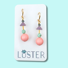 Load image into Gallery viewer, Pair of pink round dangle earrings on a Luster branded card against a light blue background
