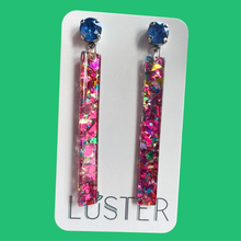 Load image into Gallery viewer, Colorful glittery earrings on a Luster branded card against a green background
