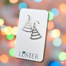Load image into Gallery viewer, A pair of silver-colored stainless steel earrings in the shape of snowy trees, displayed on a white card with the brand name 'LUSTER' written at the bottom.
