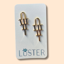 Load image into Gallery viewer, Gold brass earrings on a Luster branded card against a beige background
