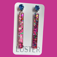 Load image into Gallery viewer, Colorful glittery earrings on a Luster branded card against a pink background
