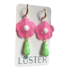Load image into Gallery viewer, Pink flower-shaped earrings with green teardrop charms on a Luster branded card.
